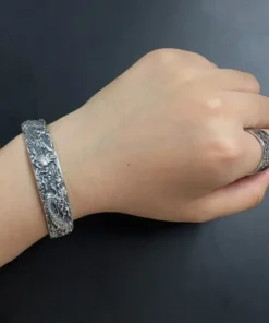 Pulsera de plata fénix tallado en la muneca