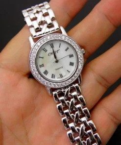 Reloj de plata mujer números romanos en la mano